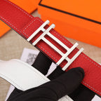 Red belt with gold H buckle centered; white stitching along the leather edge.