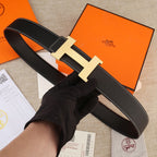 Black leather belt with textured gold H buckle and contrast white stitching