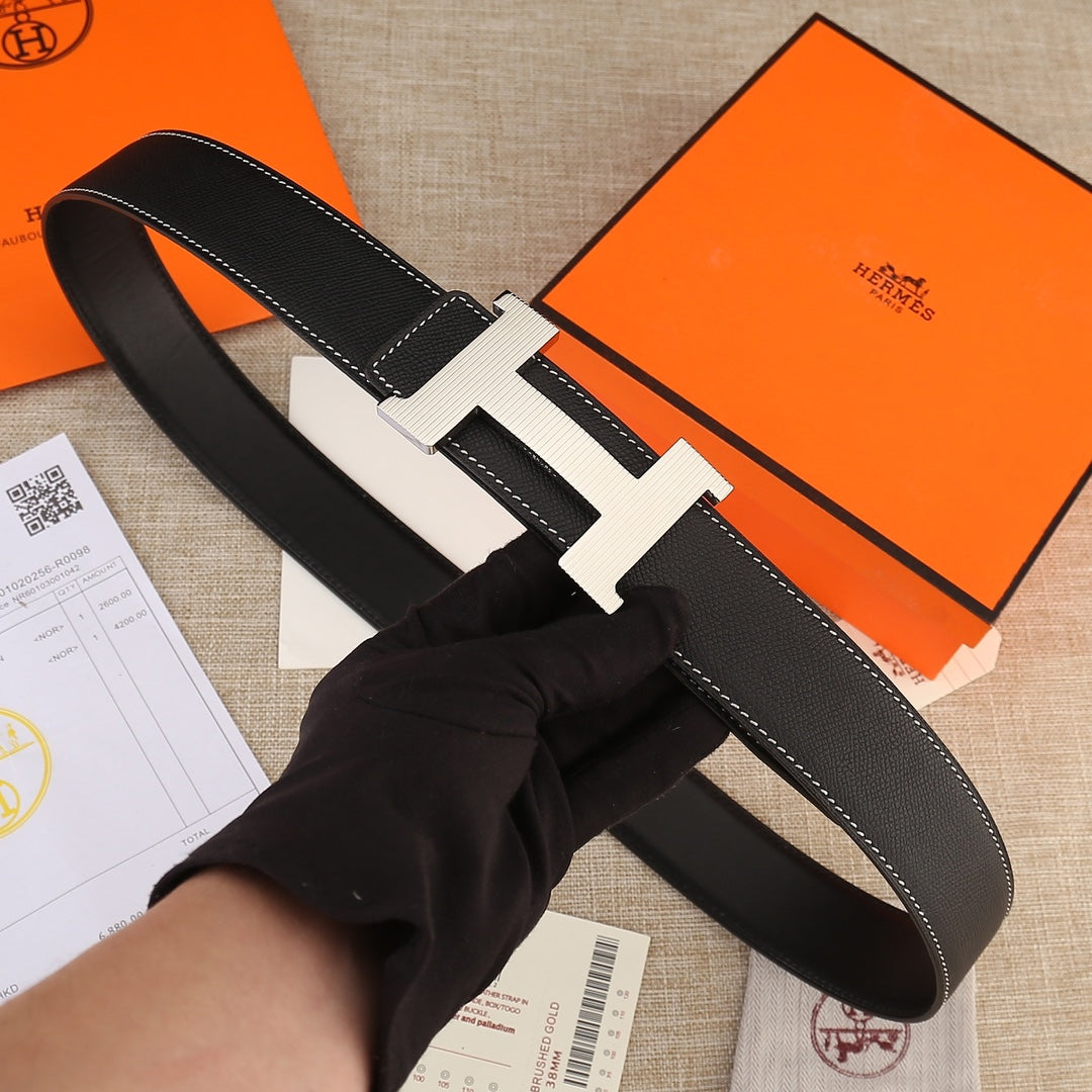 Black leather belt with gold H buckle and white contrast stitching on strap