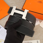 Black leather belt detail showing gold H buckle, textured leather, and white seams
