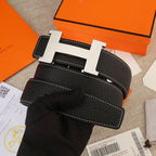 Hermes belt on display: black leather with white stitching and gold H buckle