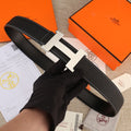 Hermes belt in black textured leather with white stitching and gold H buckle