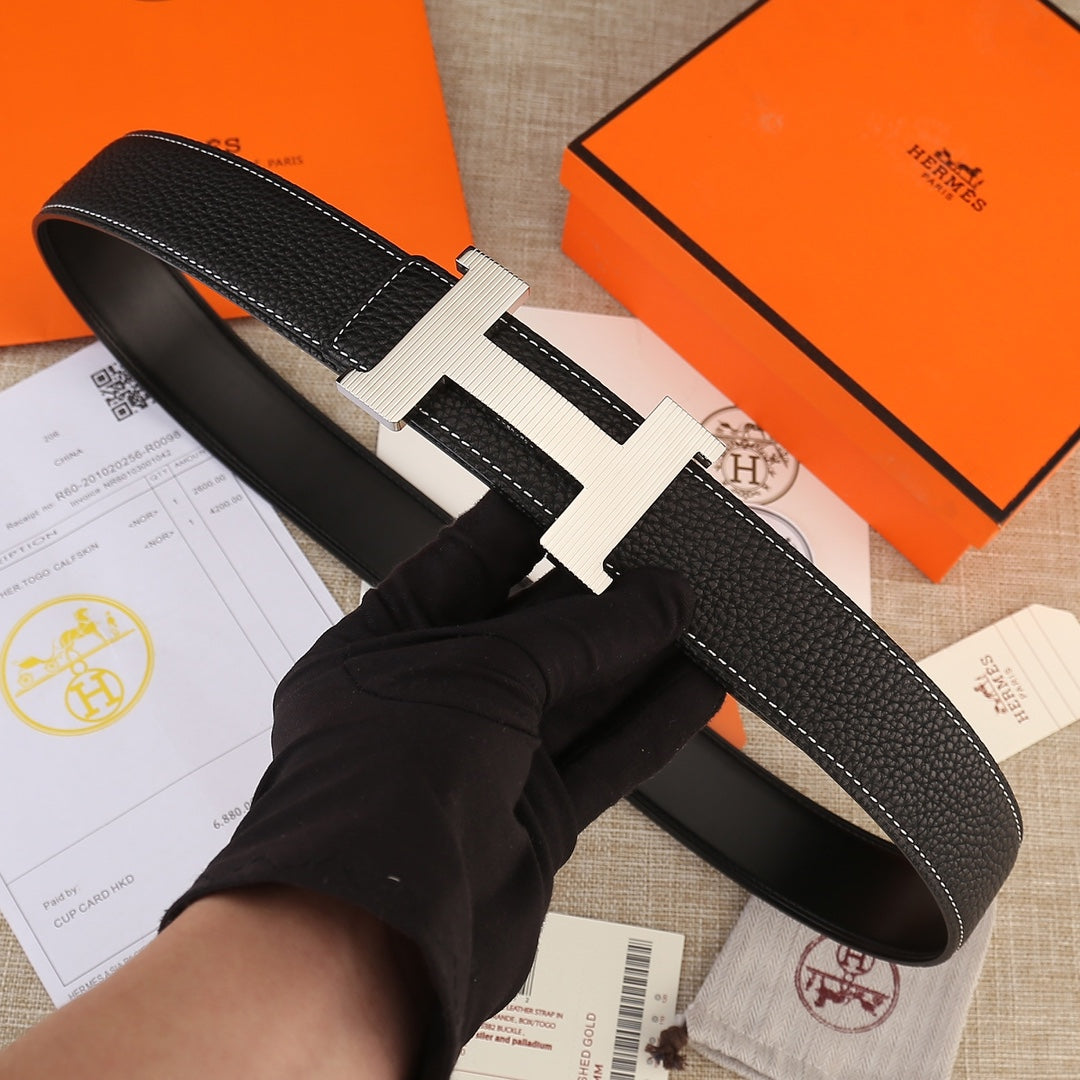 Hermes belt in black textured leather with white stitching and gold H buckle