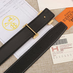 Hermes belt end detail: black textured strap with gold hardware and white stitching