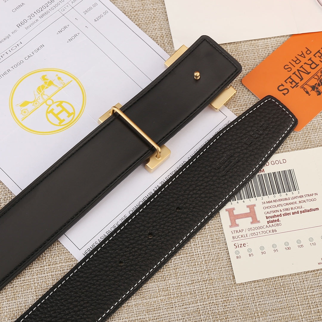 Hermes belt end detail: black textured strap with gold hardware and white stitching
