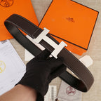 Leather belt with H-shaped buckle, dark brown textured strap and light gold hardware.