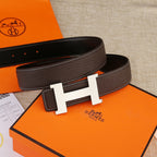 Leather belt with H-shaped buckle, dark brown strap with contrast white edge stitching.