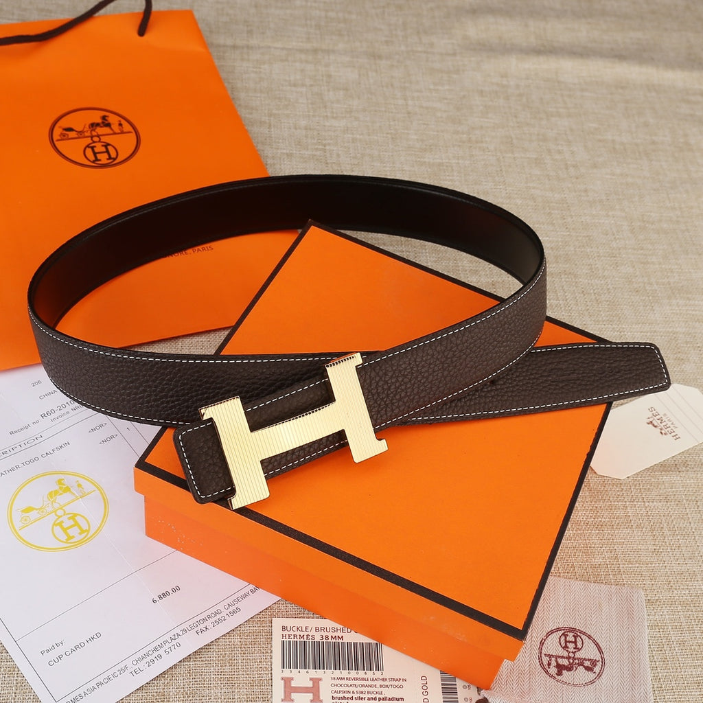 Leather belt with H buckle, dark brown strap and light gold hardware with stitched edges.