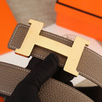 Hermes belt buckle detail with silver-tone H on brown leather and contrast stitching