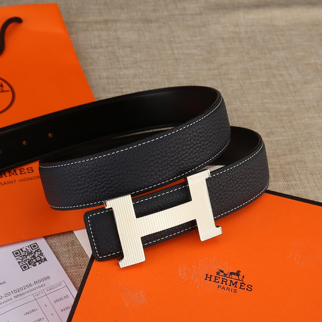 Hermes black leather belt with light gold H buckle, double-prong strap ends, and stitching.