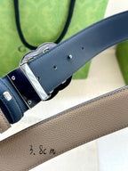 Gucci belt buckle close-up on beige leather strap with dark blue lining and silver G