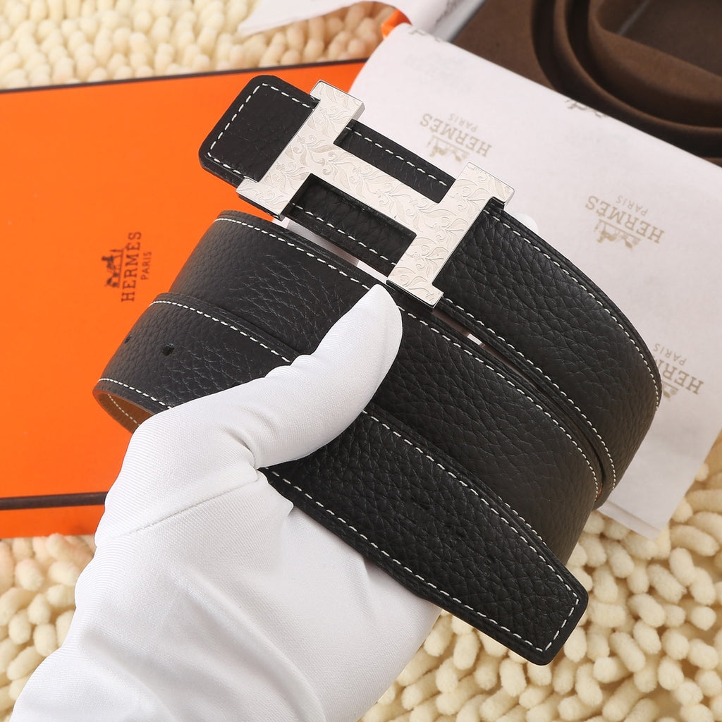 Black leather belt with silver-toned buckle, white contrast stitching, and dark keeper panel
