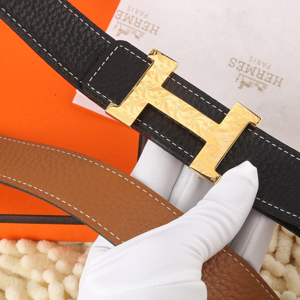 Black leather belt with textured surface, gold-tone buckle and tan underside with contrast stitching