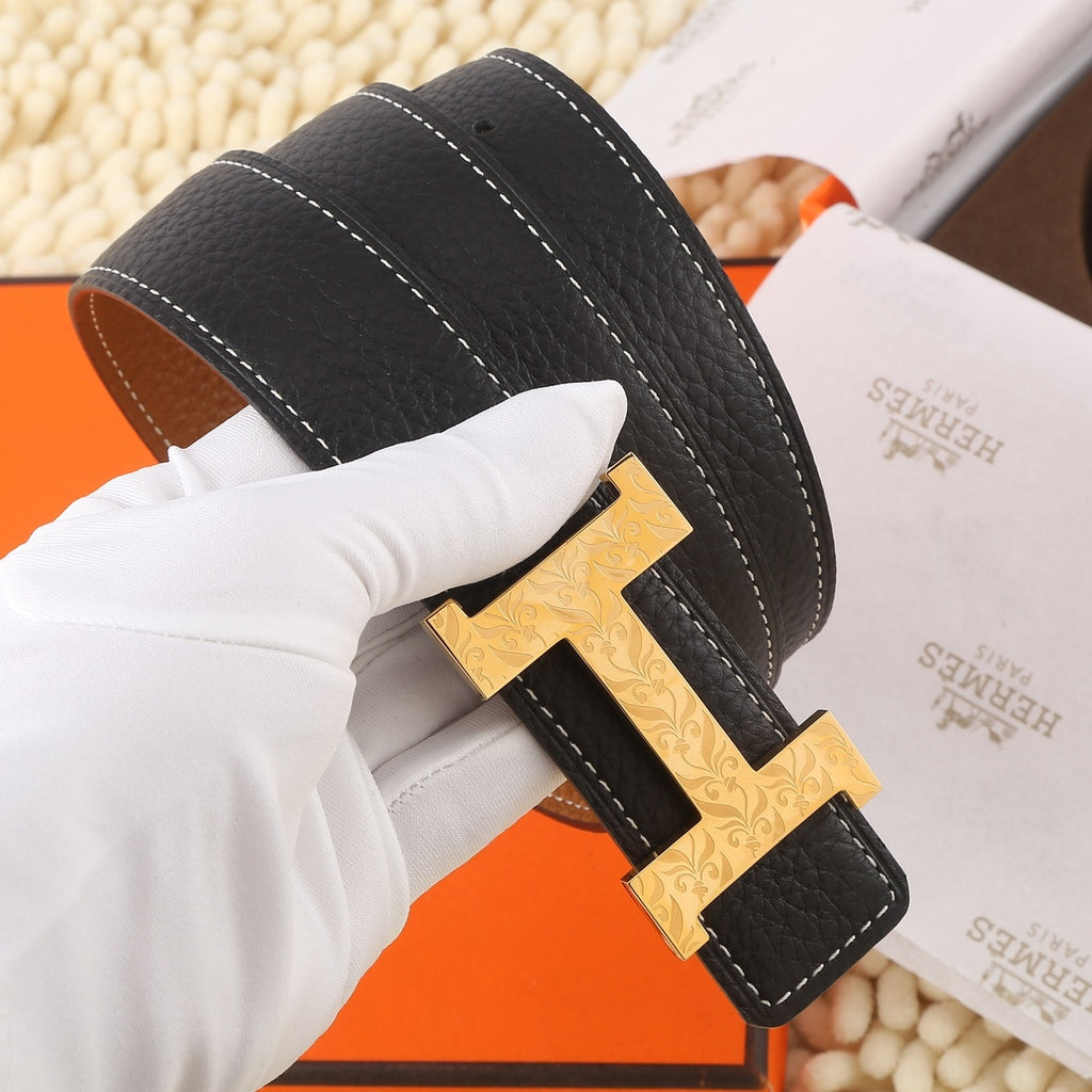 Black leather belt with gold-tone H buckle, double-stitching, and brown/tan keeper strap