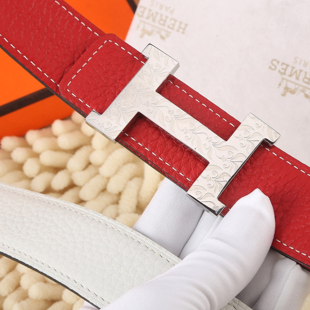 Hermes belt close-up showing red leather strap, white lining, and H buckle