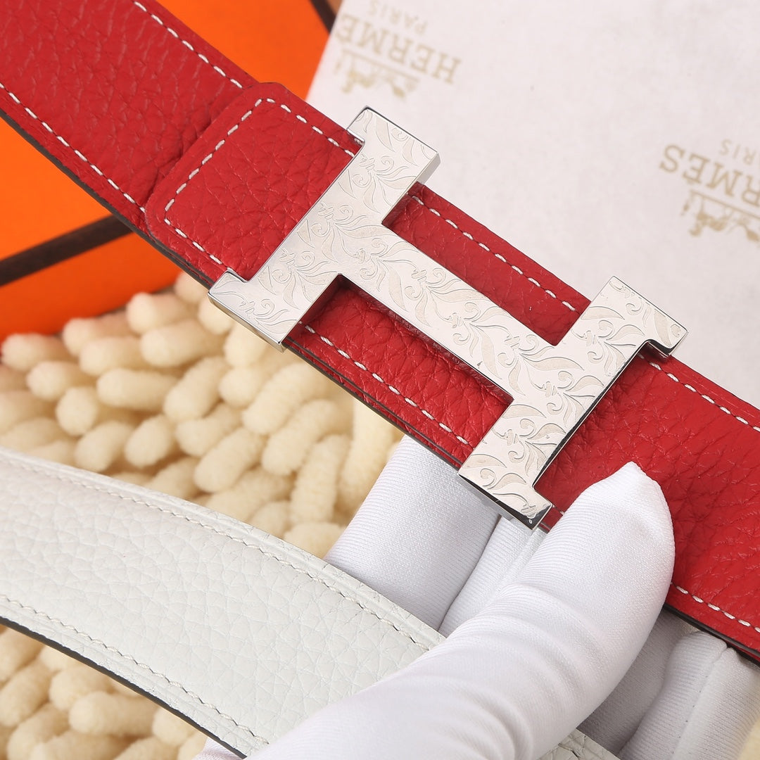 Hermes belt close-up showing red leather strap, white lining, and H buckle