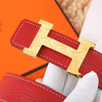 Hermes belt close-up of gold-tone H buckle on red leather strap