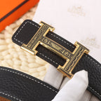 Black leather belt close-up of gold buckle with engraved frame