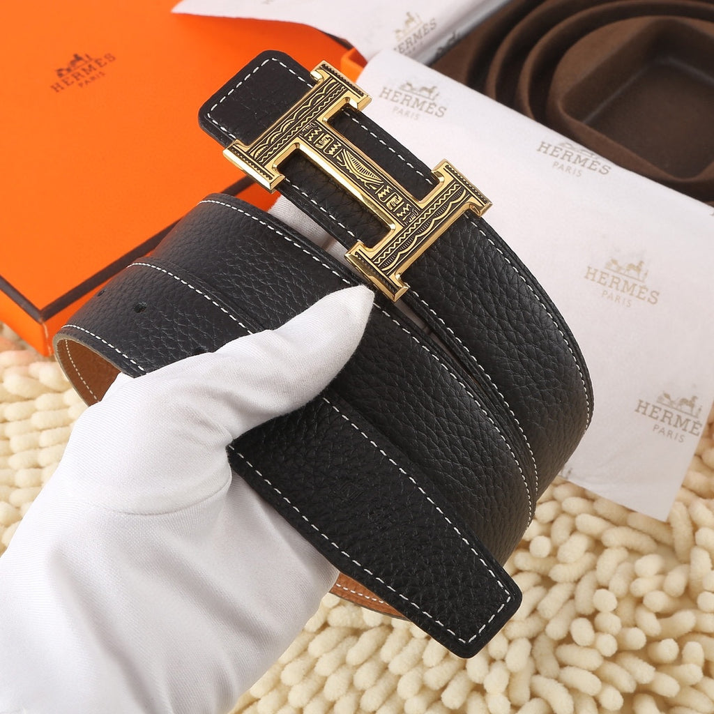 Black leather belt with gold-toned engraved buckle and contrast white stitching