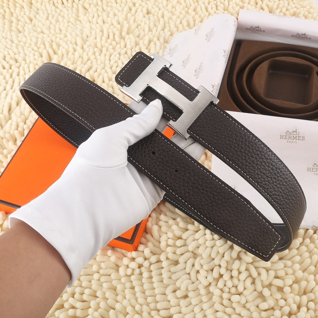 Dark leather belt with gold-tone buckle and white contrast stitching, belt loops visible.