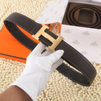 Leather belt in dark brown with gold-tone H buckle and white contrast stitching, shown flat.
