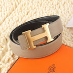 Hermes leather belt, beige outer with black inner side and gold H buckle.