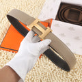 Hermes leather belt, taupe with black trim and gold H buckle.