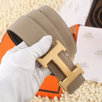 Hermes leather belt, taupe strap with gold H buckle and stitched edges.