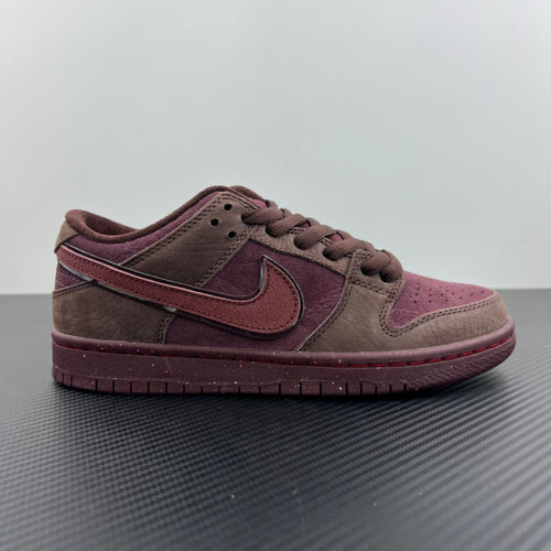 Low-top sneakers side view, taupe and burgundy panels with red-tinted swoosh and laces.