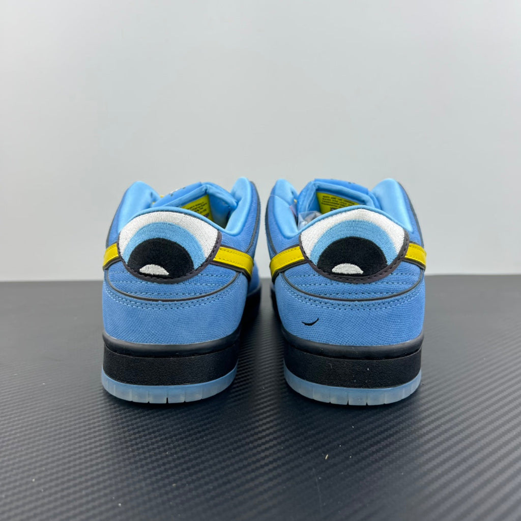 Blue low-top sneakers with graphic patch on heel and yellow lace-up detail