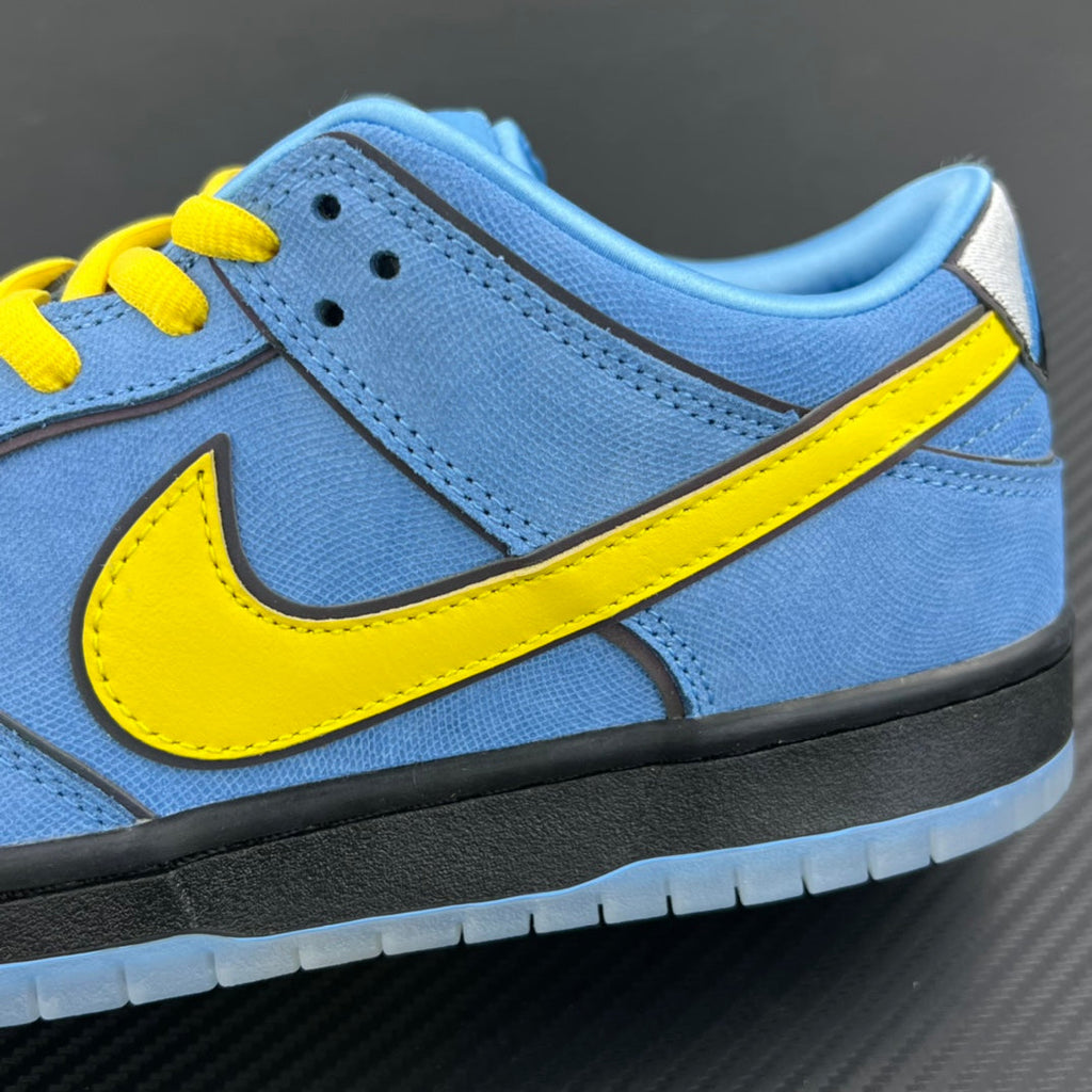 Side view of blue low-top sneaker with yellow Swoosh and black midsole