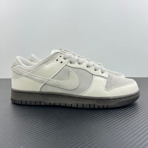 White and light gray Nike SB low-top sneakers, lace-up with swoosh on side.
