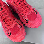Pink lace-up athletic shoes with mesh panels and chunky outsole, front view close-up