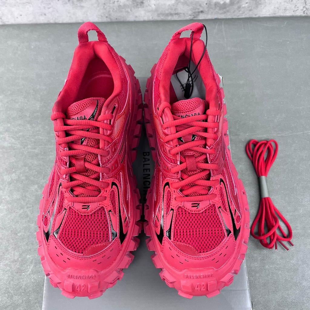 Pair of pink lace-up athletic shoes with open tongues and laces laid out