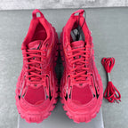 Pair of pink lace-up athletic shoes with open tongues and laces laid out