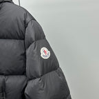Dark puffer jacket sleeve with round logo patch and stitched paneling