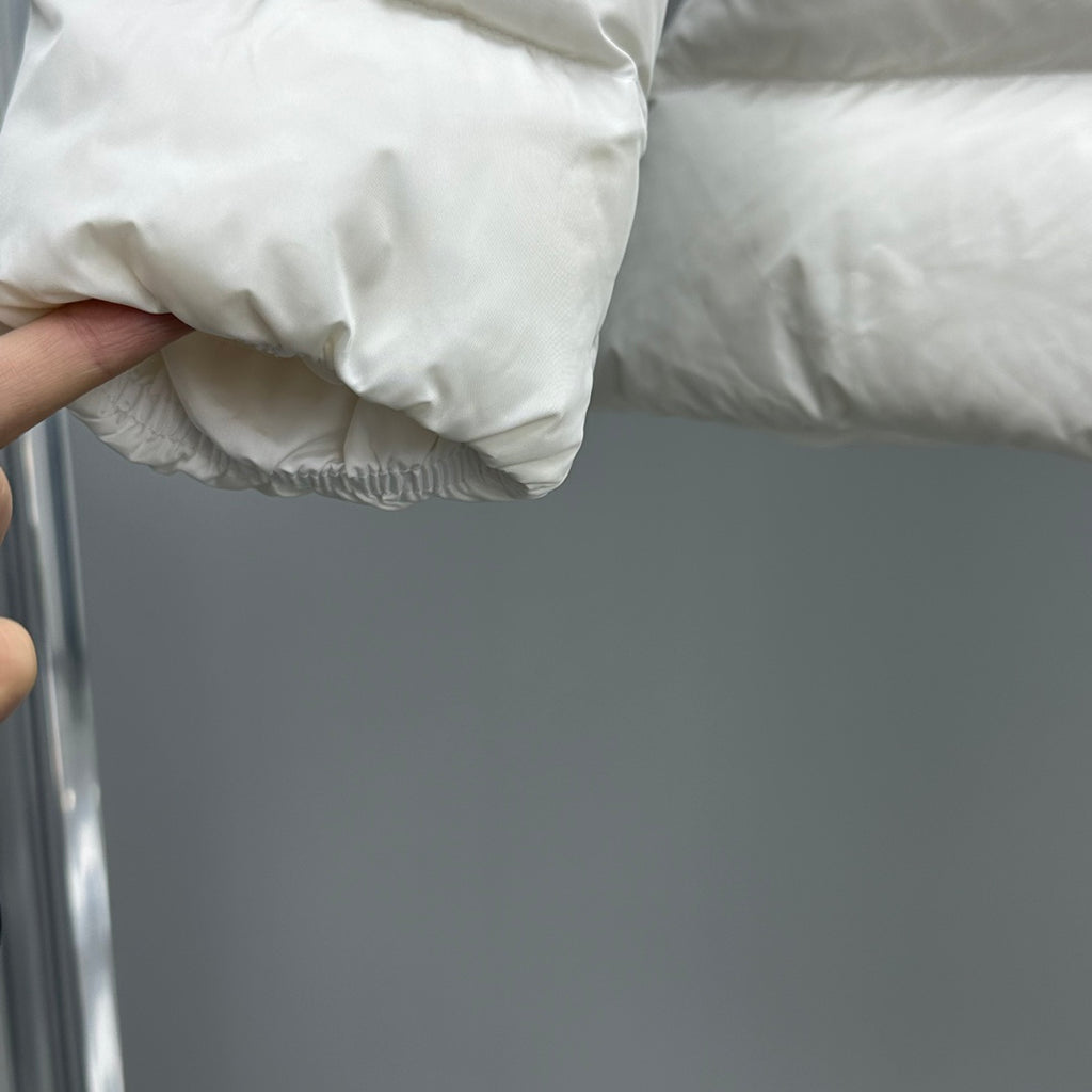 Moncler white puffer jacket fabric close-up with quilted padding and cuff hem