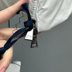 Moncler hooded puffer jacket close-up with navy strap and zipper pull