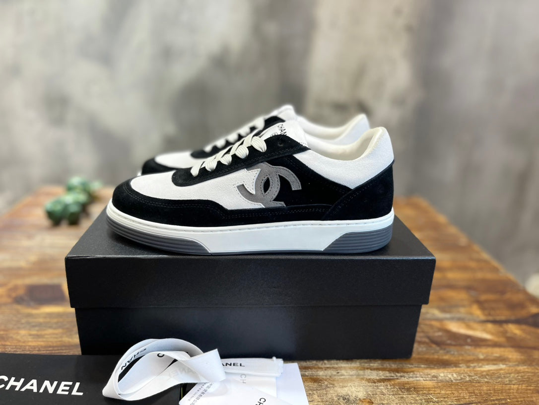 Black and white Chanel unisex low-top sneakers with lace-up front and CC logo