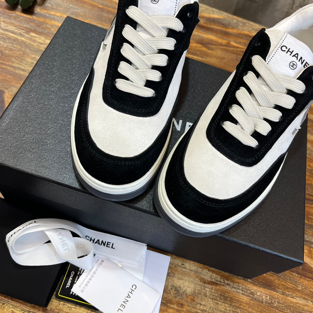 Chanel unisex sneakers close-up: black and white uppers with white laces and stitching