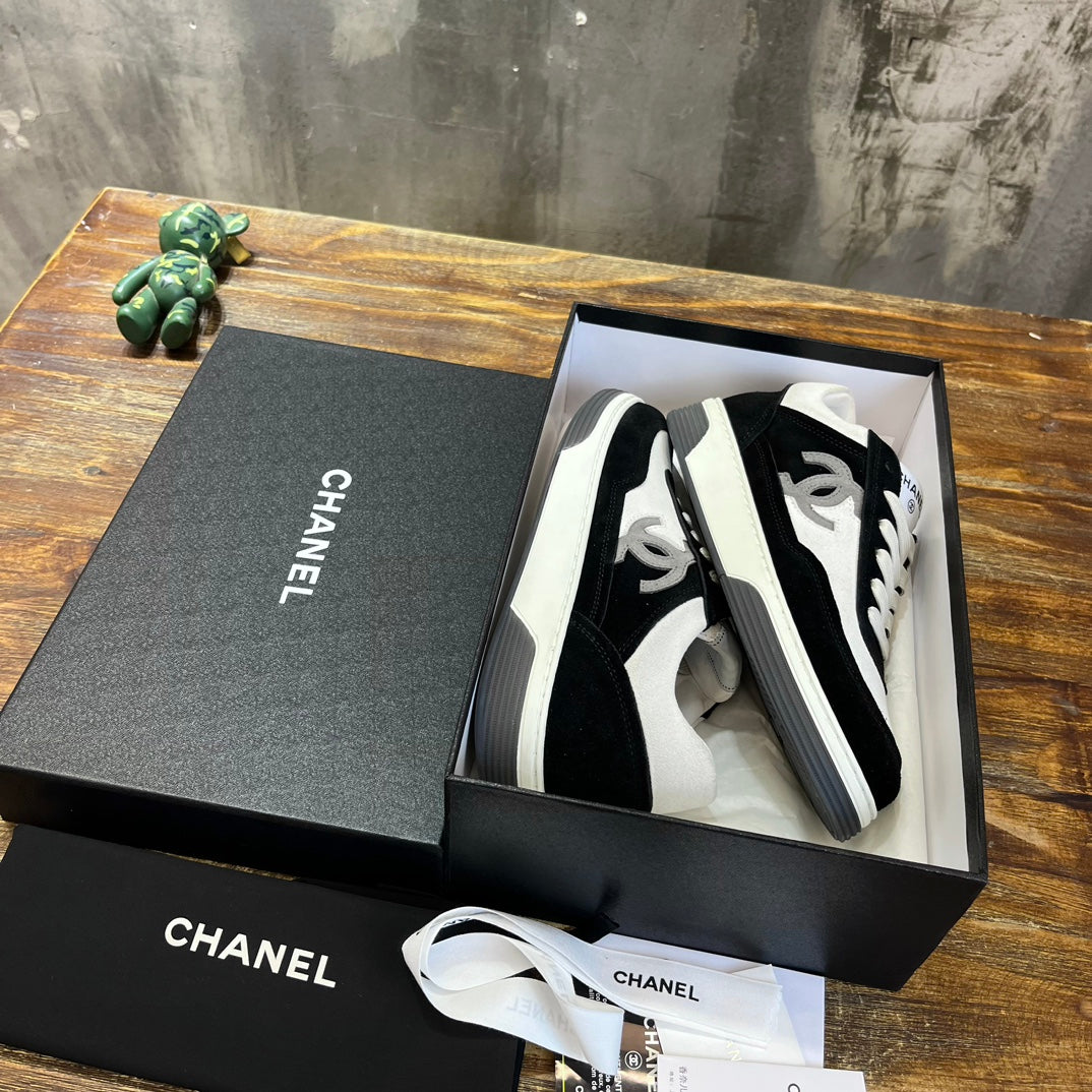 Chanel unisex sneakers in black and white, shown in open gift box