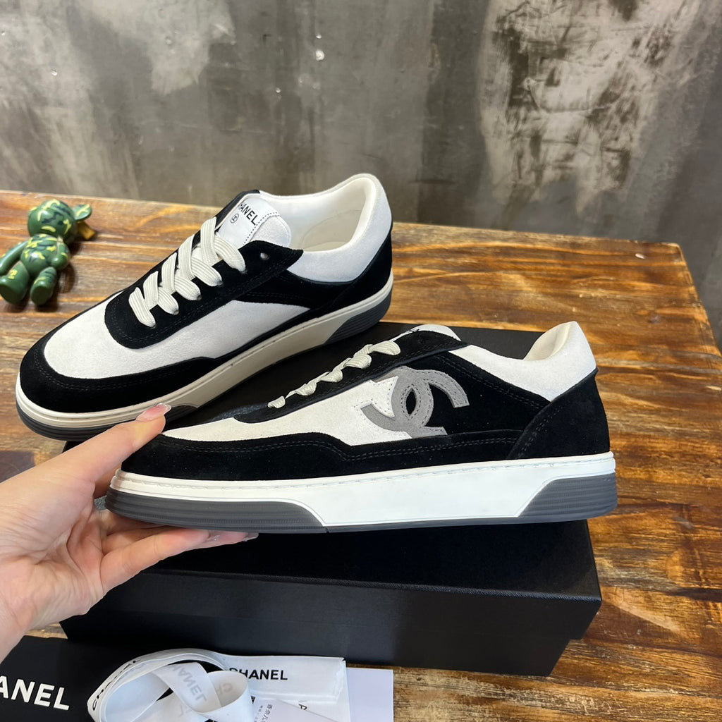 Chanel unisex low-top sneakers, black suede and white panels, side angle view