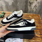 Chanel unisex low-top sneakers, black suede and white panels, side angle view