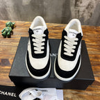 Chanel unisex low-top sneakers with white toe panel, black quarters, and lace front