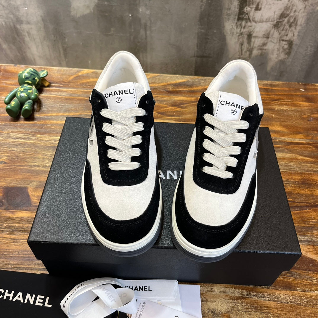 Chanel unisex low-top sneakers with white toe panel, black quarters, and lace front