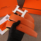 Leather belt with orange textured strap and silver H buckle with jeweled frame