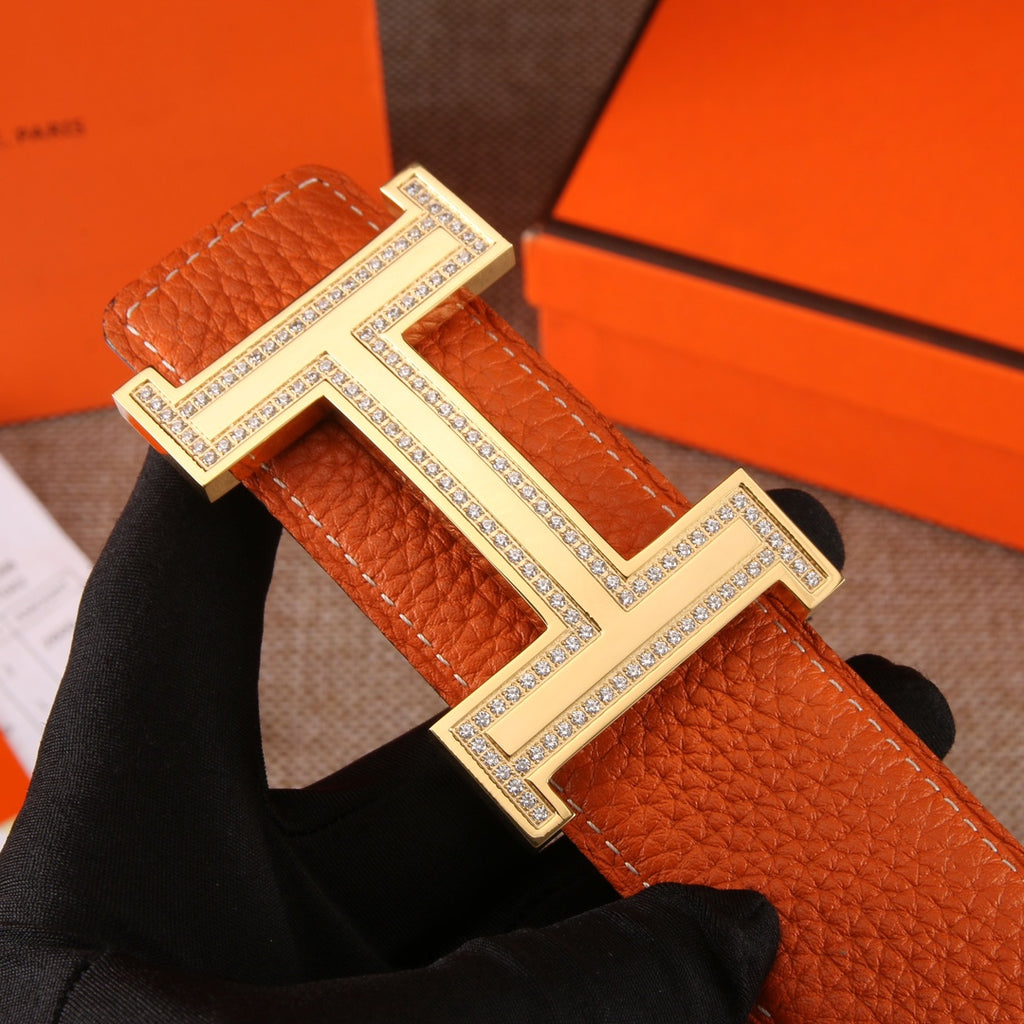 Leather belt with orange textured strap and large silver H buckle