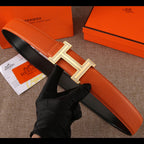 Leather belt with orange strap and silver H buckle with jeweled border