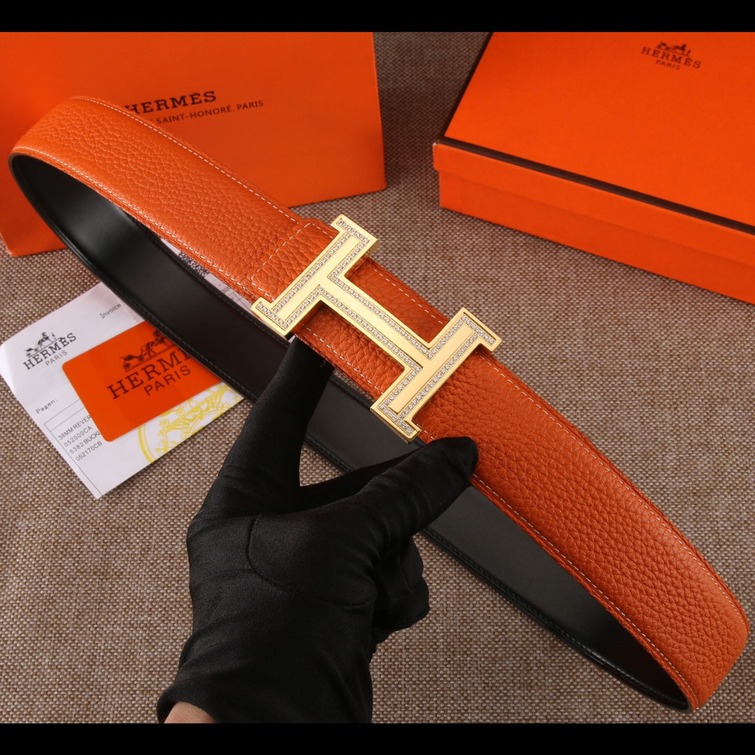Leather belt with orange strap and silver H buckle with jeweled border