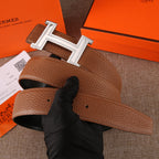Brown leather belt with silver-tone H buckle; inner edge and adjustable holes visible